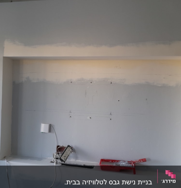 קיר גבס עם חורים, כלי עבודה ומגש צבע אדום